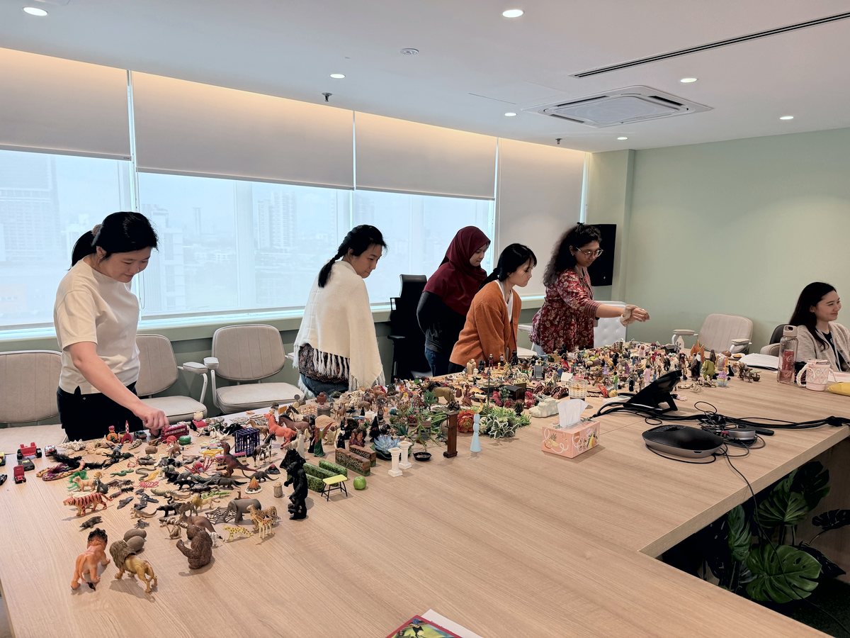 Participants choosing miniature figures during the Expressive Therapies workshop